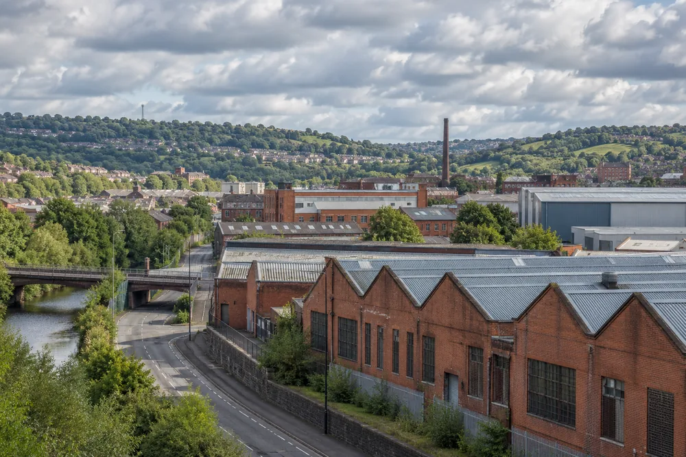 Brick industrial buildings and green hills inspired by the Sheffield area